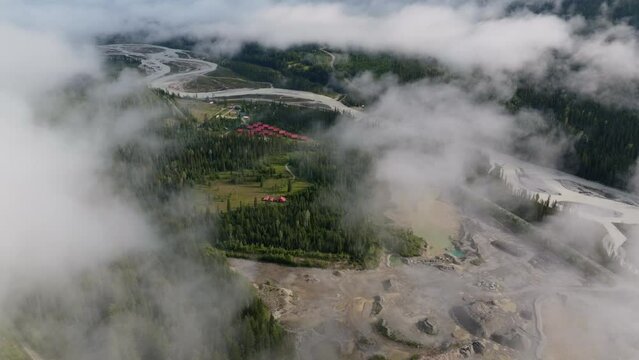Beautiful drone shot flying through clouds over forest and mountains