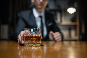 Businessman wearing a suit whiskey glass of liquor.