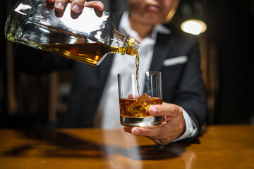 Businessman wearing a suit whiskey glass of liquor.