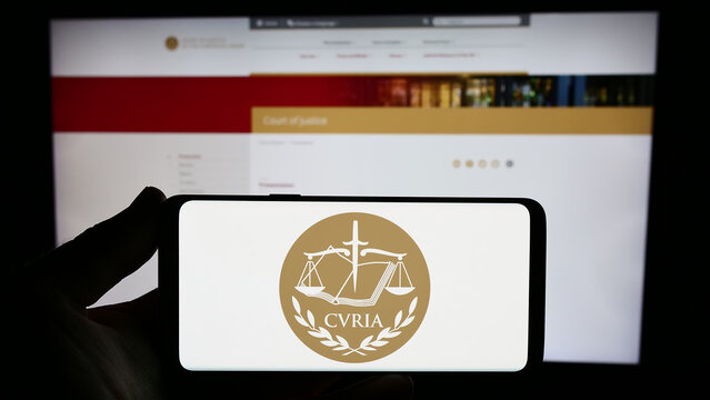 Stuttgart, Germany - 10-16-2023: Person holding smartphone with logo of EU institution European Court of Justice (ECJ) in front of website. Focus on phone display.