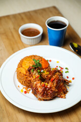 Chicken Majboos biryani rice pulao served in plate with sauce, cold drink, spoon and fork isolated on wooden board side view of arabic food