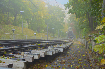 Foggy autumn landscape view of funicular cabin in the lower station. All passengers inside and waiting for departure to the upper station. Funicular is popular transport among locals and tourists