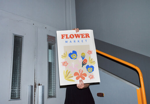 Mockup of person holding customizable vertical A2 poster, flash