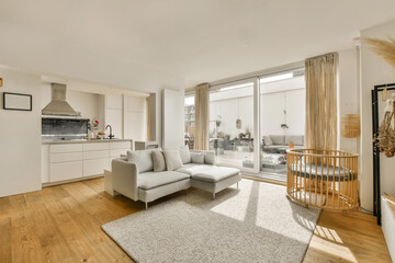 a living room with wood flooring and white furniture in the room is very spacious, but it's not too