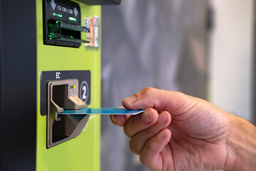close-up of male hand hold credit card, young man using device bank terminal for cash dispensing,...