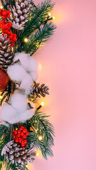Christmas tree branch with decorations on a pink background