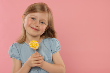 Portrait of cute girl with lollipop on pink background, space for text