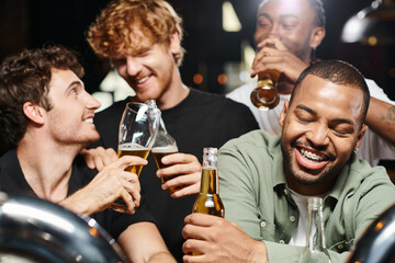happy and drunk african american man with braces smiling near male friends in bar, bachelor party