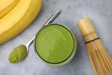 Glass of tasty matcha smoothie on light grey table, flat lay