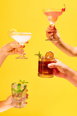 Poster. Variations of alcohol drinks. Hands with set of classic glasses of cocktails against over...