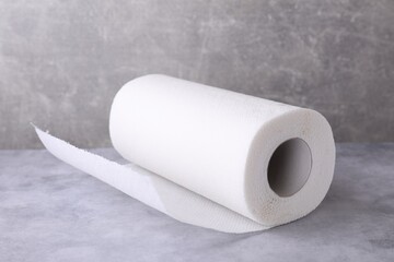 One roll of paper towels on grey table, closeup