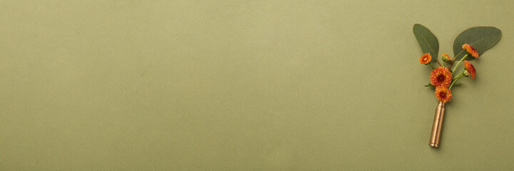 Bullet cartridge case with beautiful chrysanthemum flowers on olive background, top view. Banner design with space for text