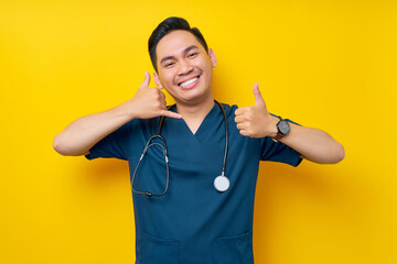 Smiling happy professional young Asian male doctor or nurse wearing a blue uniform and stethoscope...