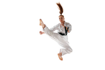 Woman professional karate fighter jumping, training martial arts in action isolated over white...