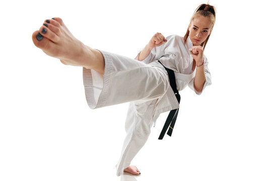 Master black belt Tae Kwon Do fighter in uniform with black belt show high kick pose isolated over white background.