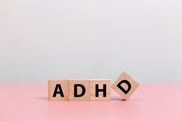 Wood cube block Abbreviation of ADHD on pink table. Attention Deficit Hyperactivity Disorder. ADHD...