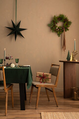 Christmas dining room interior with table, green tablecloth, wooden console, christmas wreath,...
