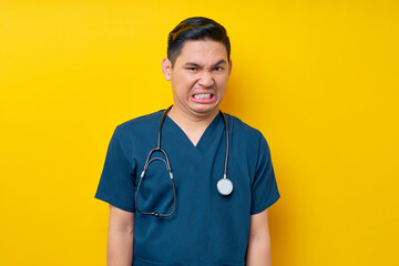 Professional young Asian male doctor or nurse wearing a blue uniform looking at the camera and...