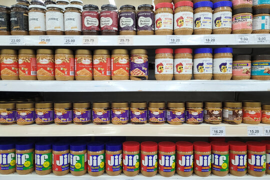 PENANG, MALAYSIA - 12 OCT 2023: A variety of spreadable jams, peanut butter, and chocolate spreads are showcased on a display shelf at the Giant Grocer supermarket in Penang
