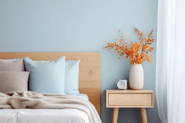 Foto op Plexiglas Modern minimalist bedroom interior in blue tones. A bouquet of dry hydrangea and autumn leaves in a vase on the bedside table. © July P