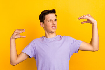 Photo of irritated annoyed young man showing blah-blah-blah gesture isolated yellow color background