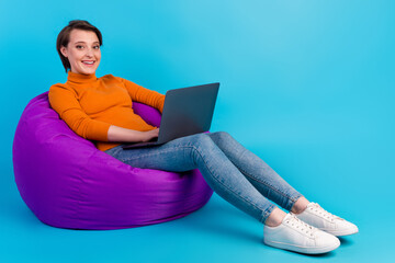 Photo of young lady student sit beanbag typing modern gadget netbook isolated blue teal color background