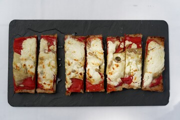 slices of flat bread with different toppings on a slate platter