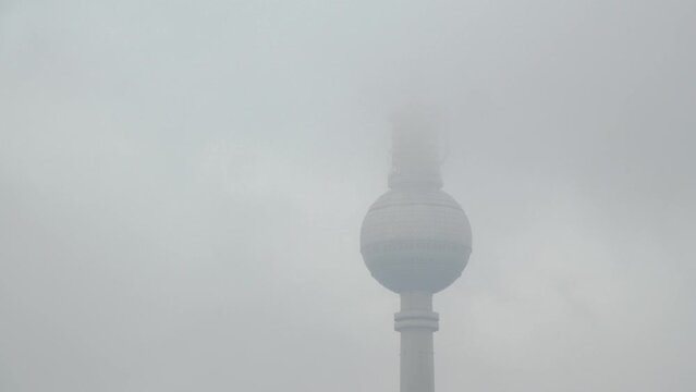 Time Lapse of Berlin Television Tower hiding behind Clouds in Misty Germany