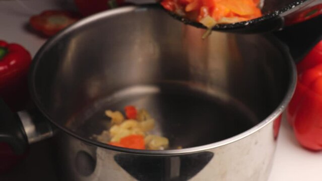 Place the sautéed carrots and onions into a saucepan for preparing stuffed peppers. Step-by-step cooking in a saucepan