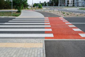 Pedestrian crossing with white stripes on asphalt and marking for bicycle lane - obrazy, fototapety, plakaty