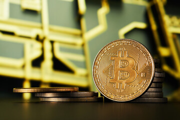 Closeup of Golden Bitcoin cryptocurrency with blurred computer printed circuit background