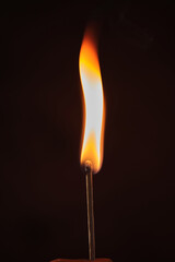 a lighted match on a dark background