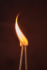 two lighted matches on a dark background