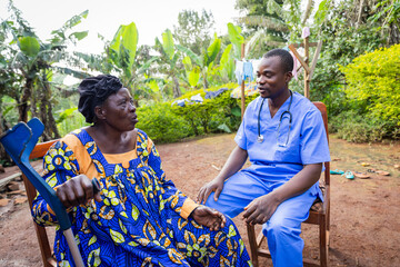 A young African doctor pay a visit to an old ill woman. Home visit to a sick elder