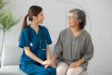 Happy caregiver and elderly patient smile and looking camera nursing at home. Asian senior man and...