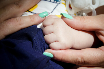 Babys hand held by her mothers hand