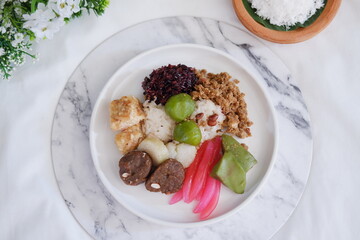 Jenang Madura is a typical Indonesian food that consists of black sticky rice, porridge marrow, jenang grendul and red pearls that were given palm sugar and coconut milk
