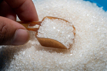 white sugar in spoon on wooden table background