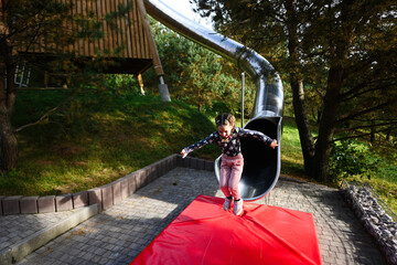 Little girl having fun on the playground in the park. Healthy lifestyle.