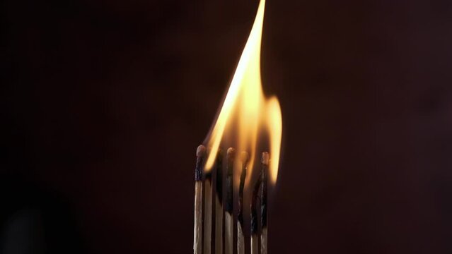 a row of matches are lit on a dark background