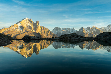 Man, Mountains and Reflection in Lac Blanc Lake at Sunset. Golden Hour. Chamonix, French Alps, France