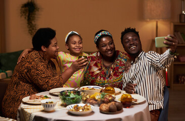 Joyful Black family video calling friends from another city when celebrating Kwanzaa