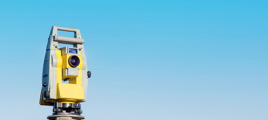 Close-up of surveyor optical equipment  tacheometer or theodolite on construction site with selective focus and blurred background - obrazy, fototapety, plakaty