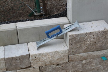 Errichten einer Steinmauer im Garten - 667059707