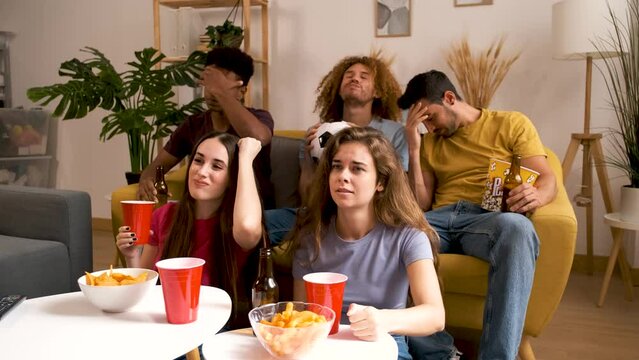 Group of devastated sports fans watching their football team losing on TV at home.
