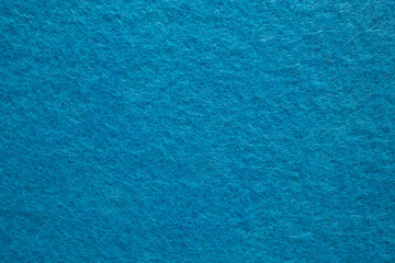 Felt fabric texture with visible fiber, blue color abstract pattern backdrop,