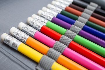 Rainbow colored pencil crayons with eraser, arranged in a pencil box, back to school abstract...