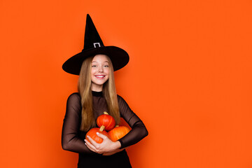 Photo of beautiful positive magician girl hands hold pumpkins empty space blank isolated on orange color background