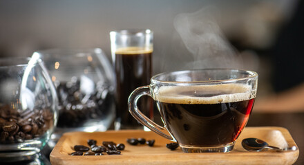 black drip coffee in glass cup, Barista making drip coffee by pouring spills hot water on coffee bean. Barista serve holding cup of hot black coffee or americano for serve on wooden table cafe shop