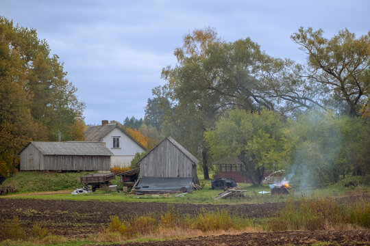 landscape with old wooden buildings in Latvia countryside in colorful autumn.